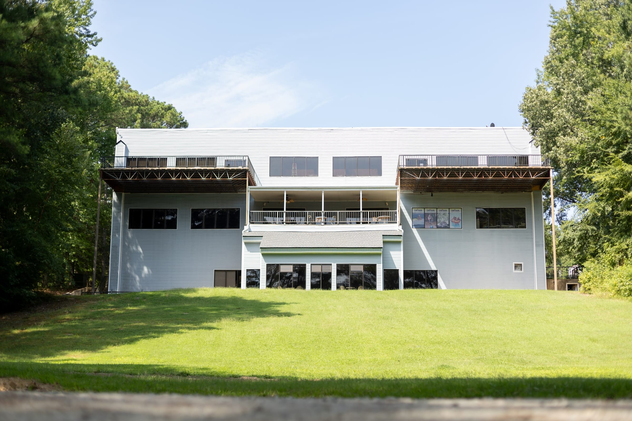 The Boulder House, three stories above its lawn under a blue sky