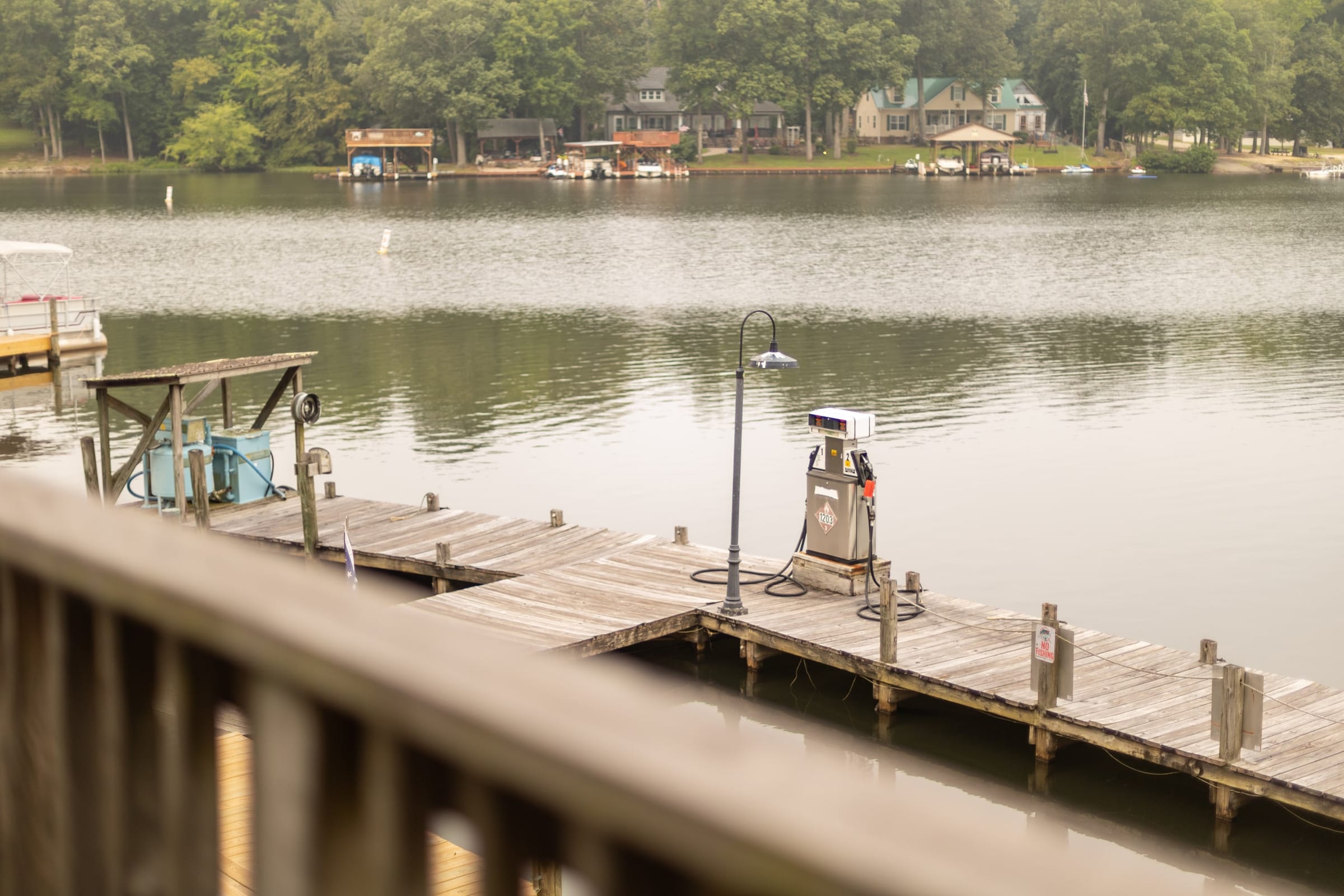 Fuel pump at the end of the marina dock, boathouses across the water