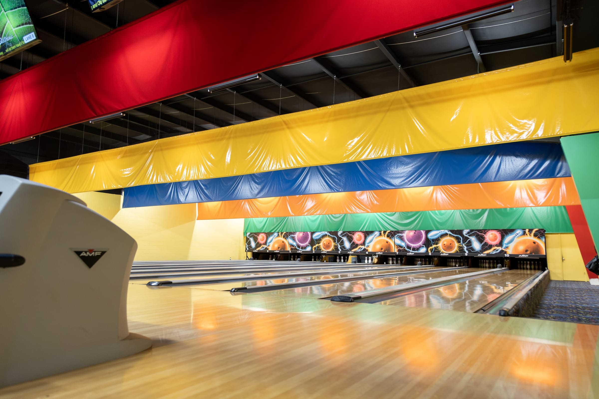 Bowling lanes with rainbow bumpers stretching to the pins