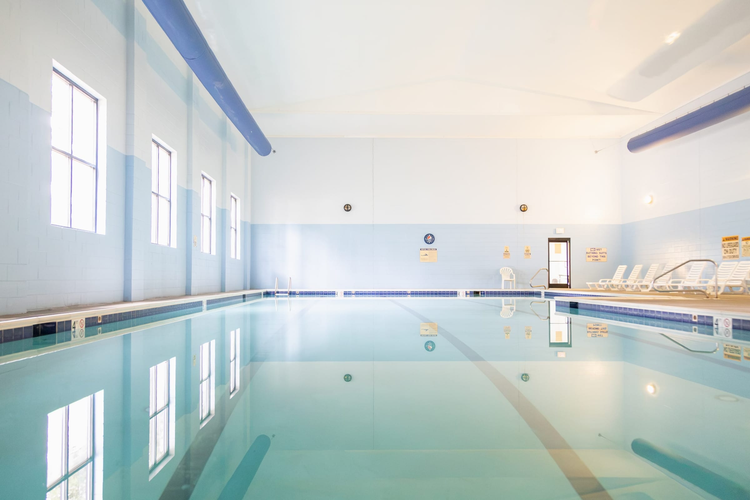 Indoor pool with loungers along the windowed wall