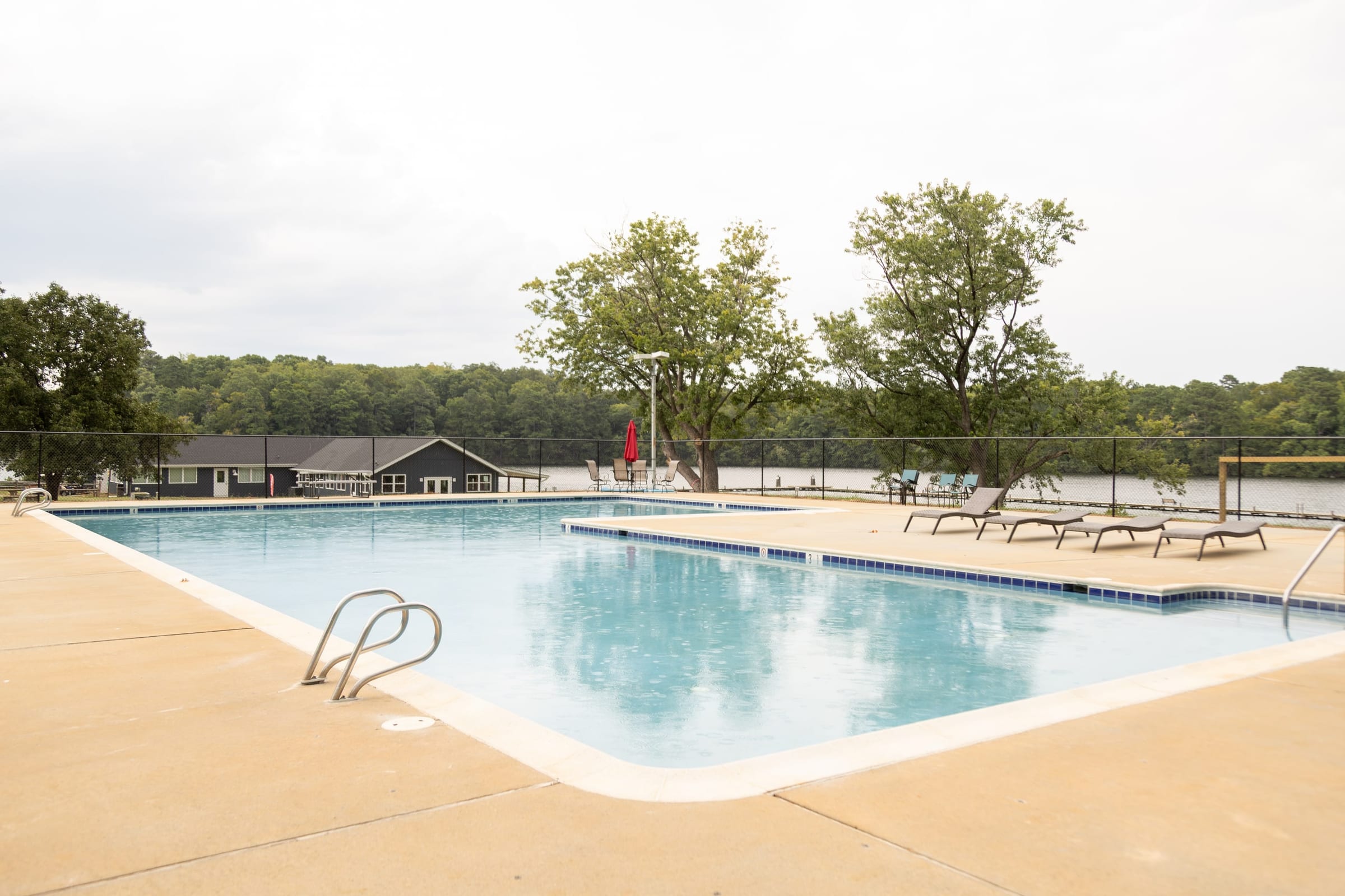 Outdoor pool with loungers and diving rails under summer haze