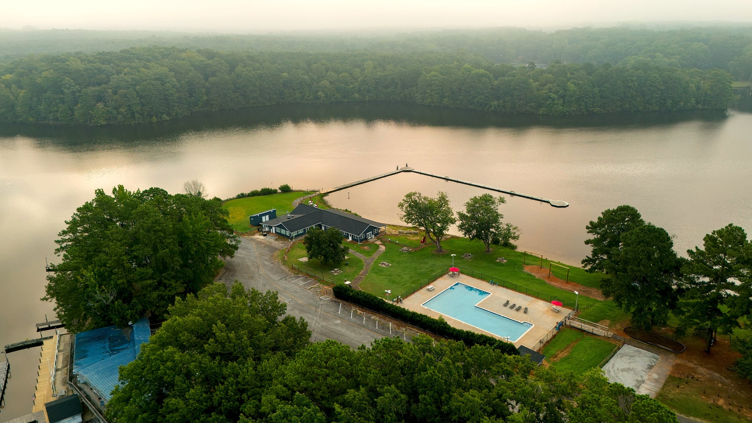 Aerial of pool, courts corner and restaurant point at the cove mouth