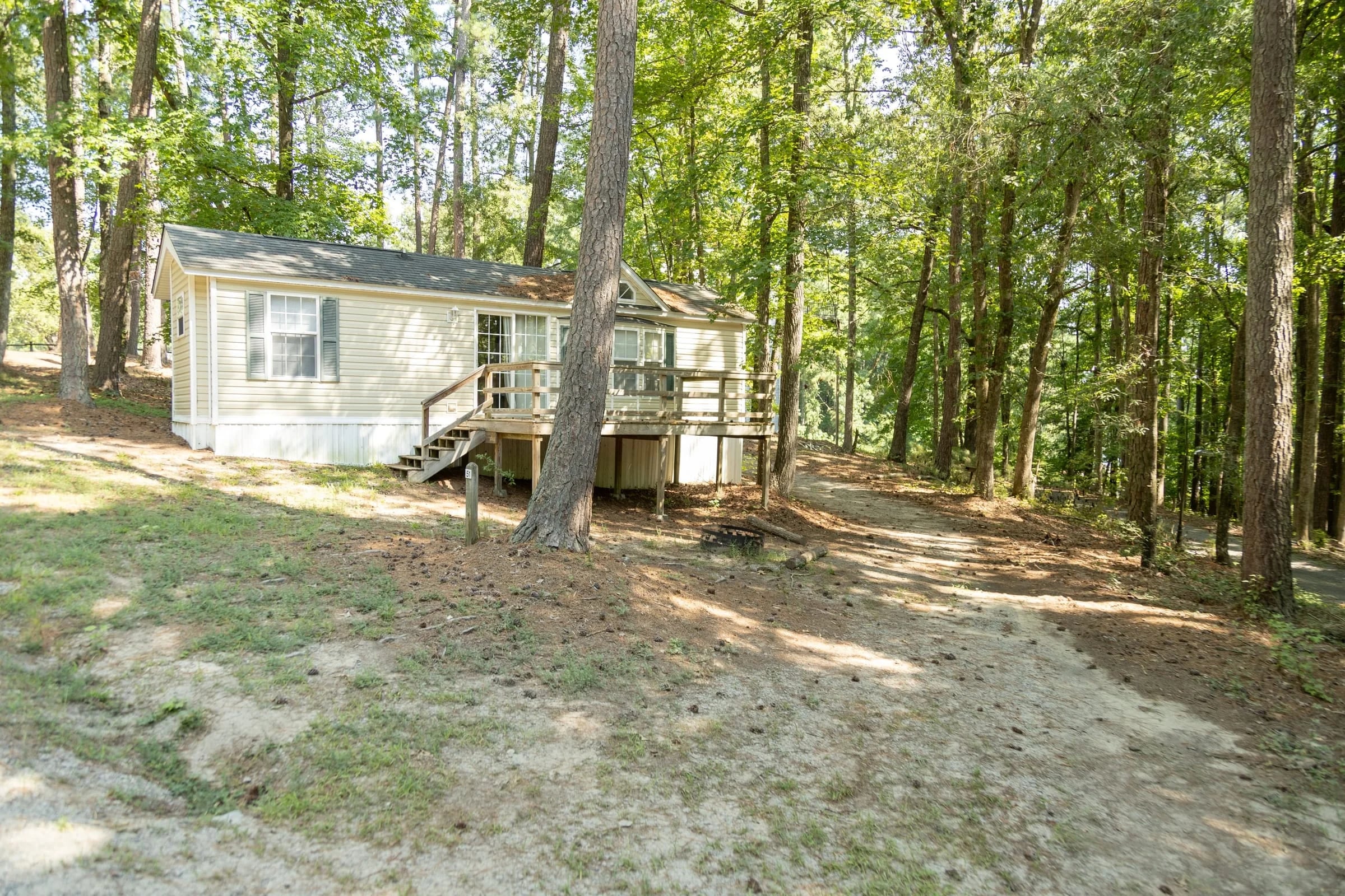 Rental cottage on its wooded rise with front deck