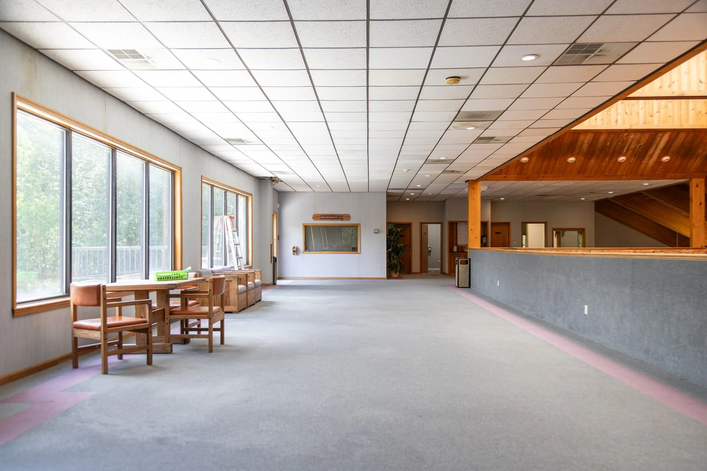 Open games room with striped carpet and wooden tables